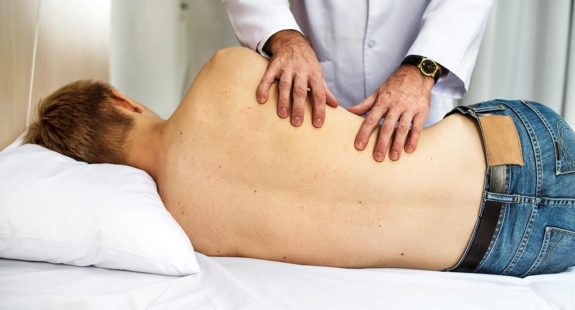 A man laying on his side receiving chiropractic treatment