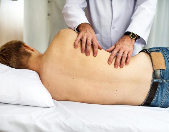 A man laying on his side receiving chiropractic treatment