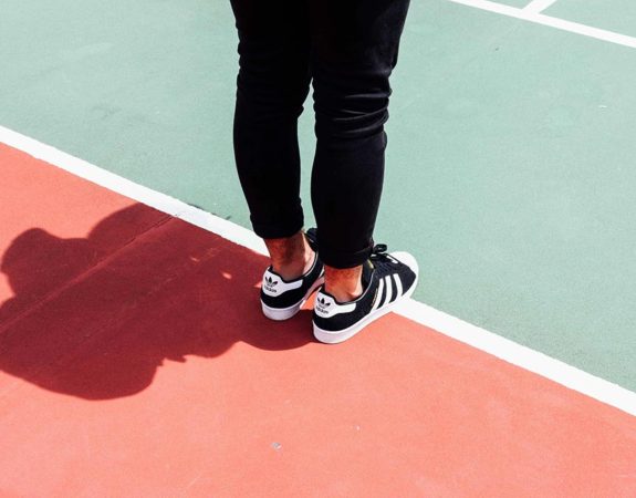 The feet of someone standing on a track