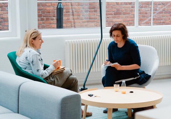 A woman talking while a psychotherapist takes notes.